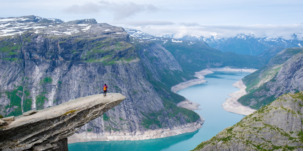 A hiker stands on the edge of the Trolltunga cliff in Norway.