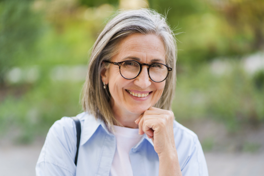 Senior woman and illustrated brain on gray background.